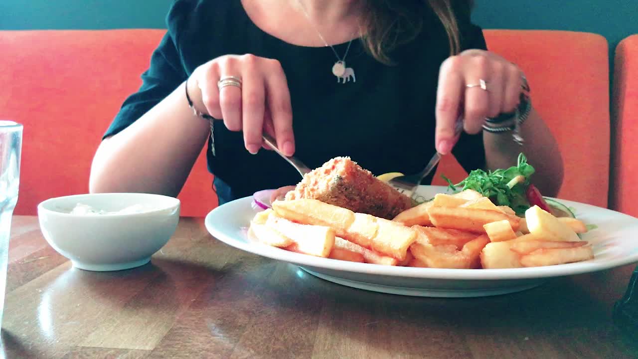 레스토랑에서 맛있는 저녁을 먹는 젊은 매력적인 소녀