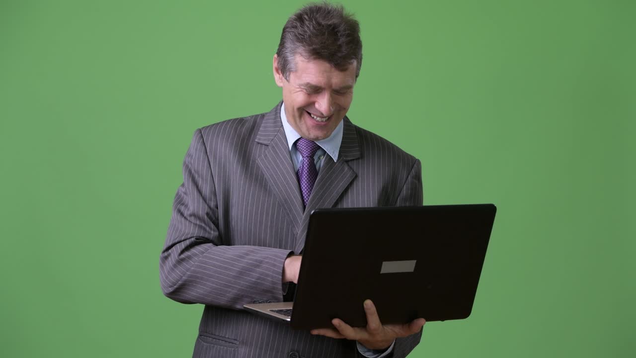 hombre de negocios maduro y guapo contra un fondo verde