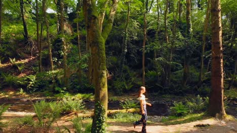 woman walking in the forest on a sunny day 4k