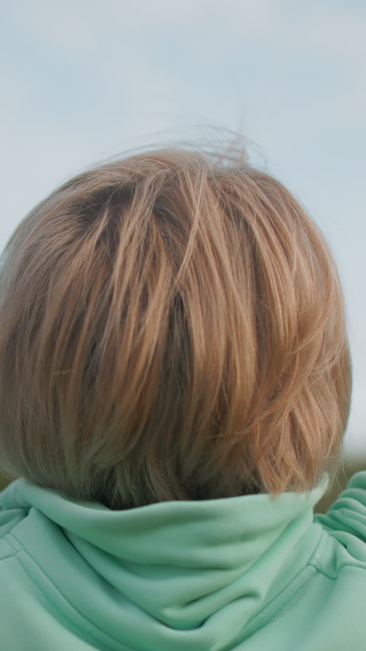 Woman enjoys outdoor air, Lady peacefully inhaling park breeze, Calm female taking in fresh outdoor environment, Serene woman dressed in mint hoodie absorbs tranquil park atmosphere effortlessly