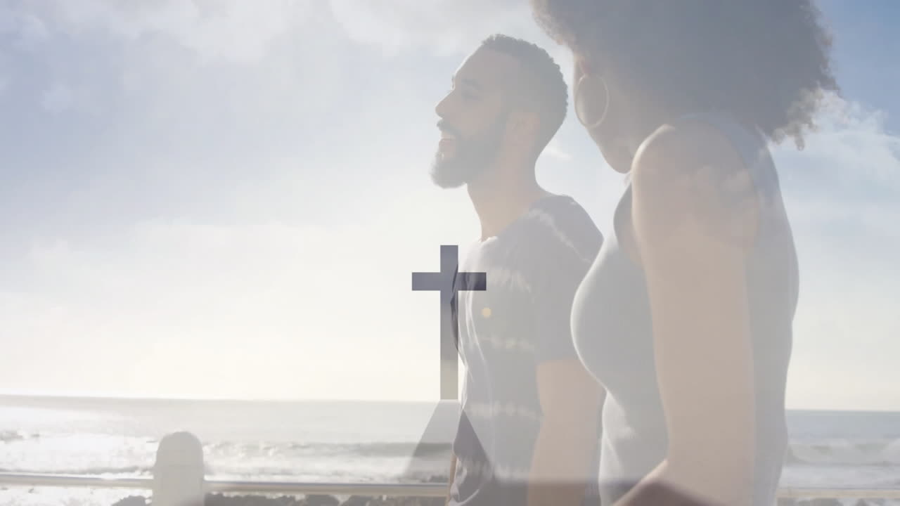 Walking by ocean, man and woman with cross symbol animation overlay
