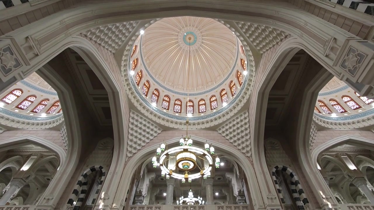 Vista dal basso della cupola interna decorata di una moschea e lampadario