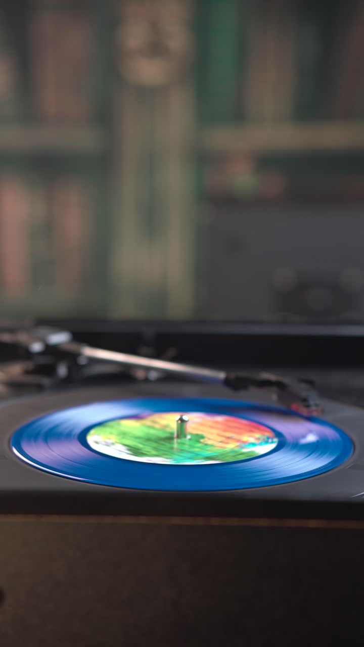 Visuale verticale, avvio della riproduzione di un singolo disco in vinile blu su giradischi