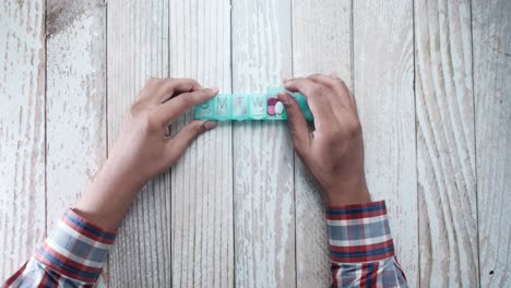 persona que utiliza un organizador de pastillas semanal