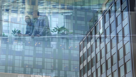 animation of office building over business people talking in modern office