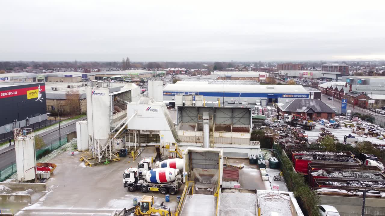 Industrial CEMEX cement manufacturing factory yard aerial view with trucks parked around machinery