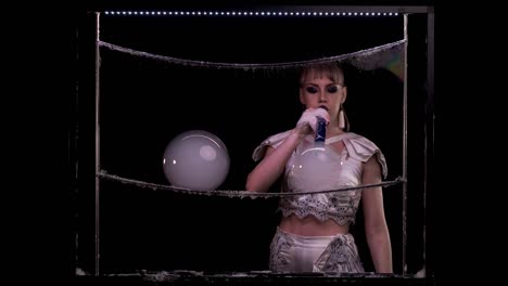 stylish girl does tricks with soap bubbles. she blows two large bubbles with pipe