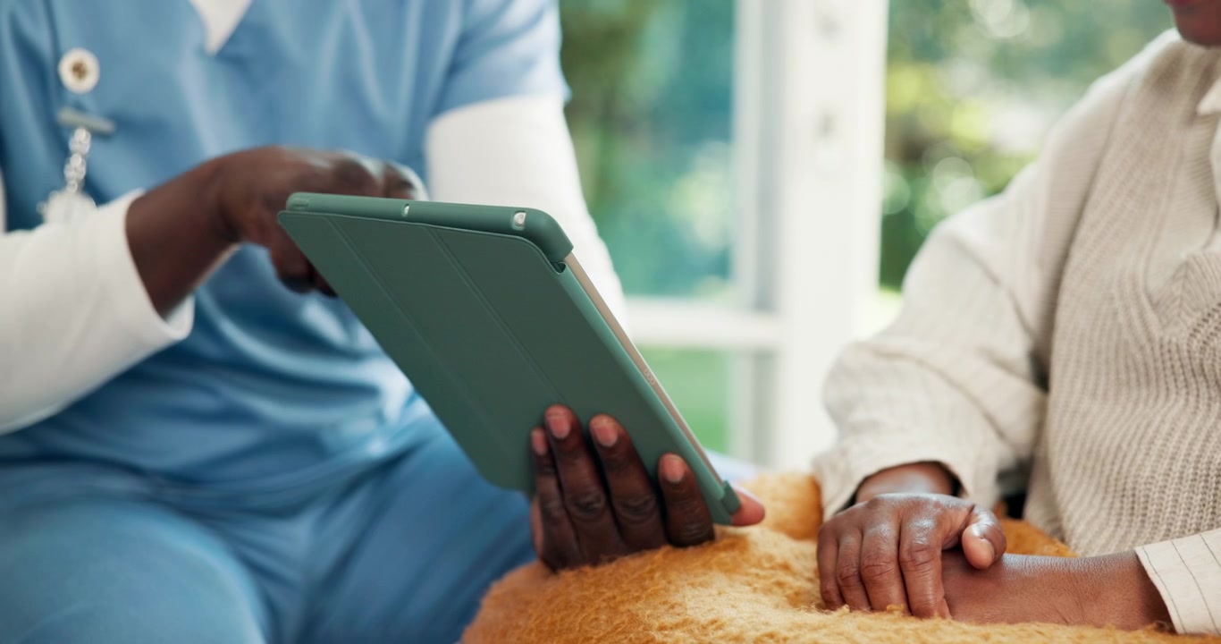 Healthcare Professional Discussing Medical Information With Senior Patient Using Tablet