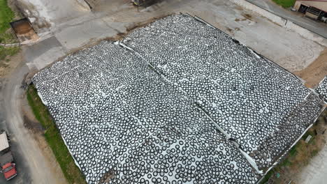 large silage pile covered with white plastic and stores to store animal feed