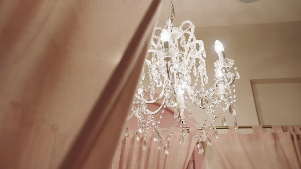 머리 위에 매달린 크리스탈 들리어가 있는 쾌적한 침실 - 낮은 각도
