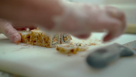 cook prepares a japanese roll decorated with roasted eel fish skin slicks