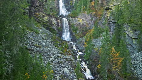 approaching on waterfalls flowing from steep rock mountains in sweden