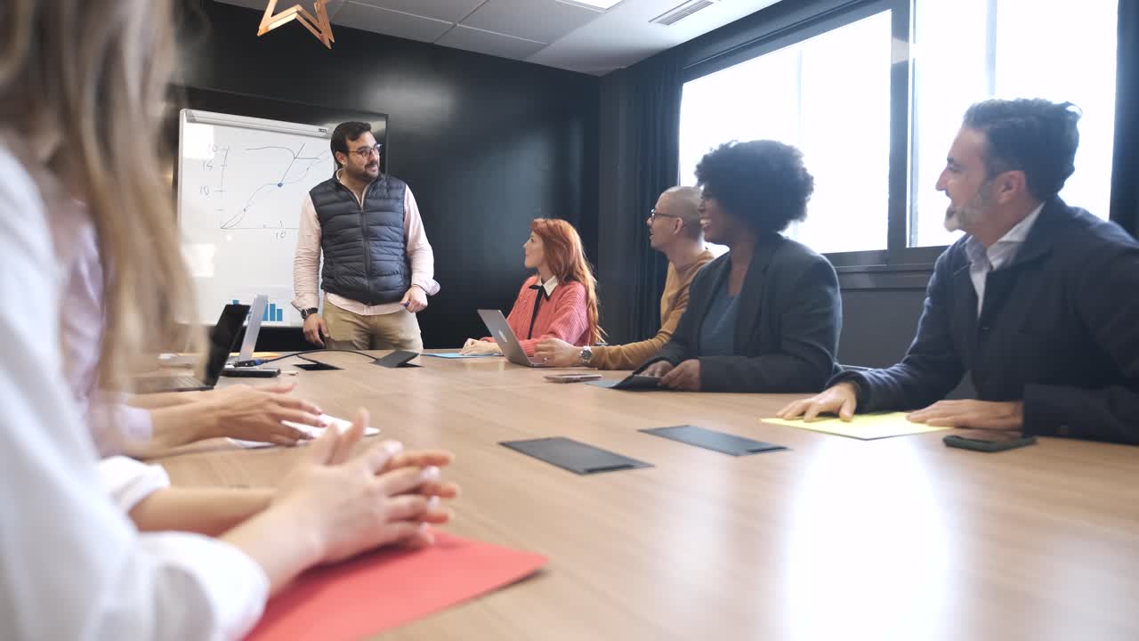 Businessman discussing with colleague during presentation in conference room