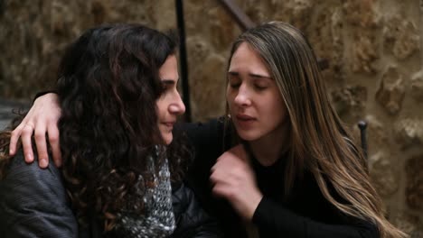 girlfriend comforting and cheering her sad girlfriend up after bad breakup at a coffee place.