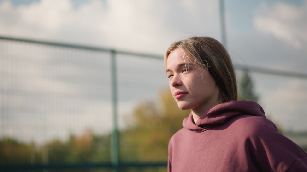 cerca de dos personas corriendo una al lado de la otra en el patio al aire libre, una con tela a cuadros y la otra con capucha roja, mostrando sus expresiones decididas y energía