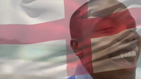 Animation-of-flag-of-england-waving-over-close-up-of-smiling-african-american-woman