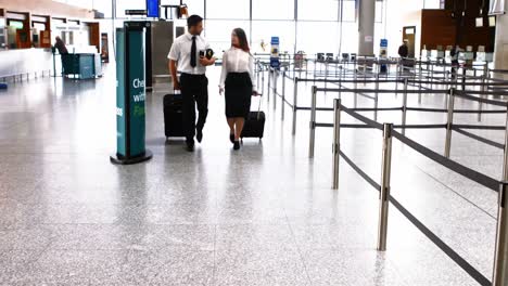 pilot and female flight attendant walking with luggage