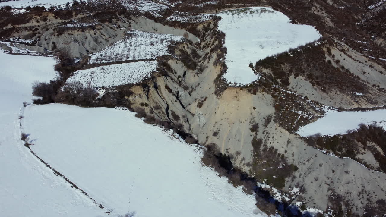 Snowy Valley with Eroded Hills