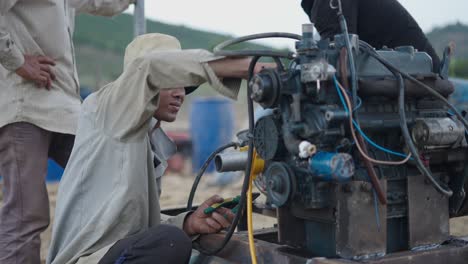 Workers repairing a diesel engine