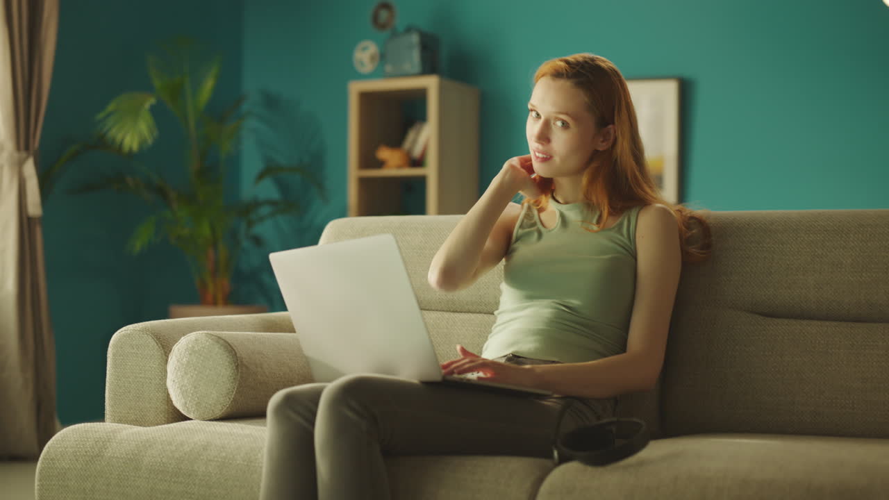 женщина с ноутбуком смотрит на камеру