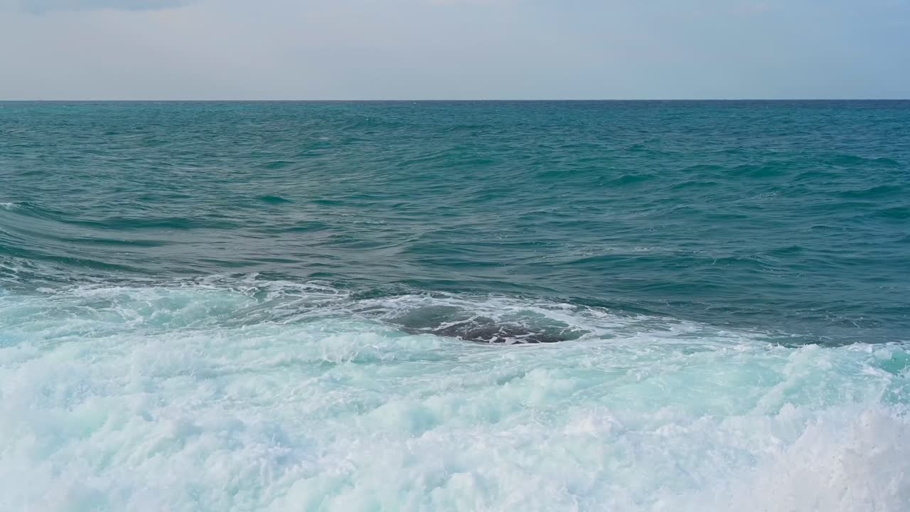 Onde che si infrangono sugli scogli sulla riva a Kyrenia, Girne, Cipro