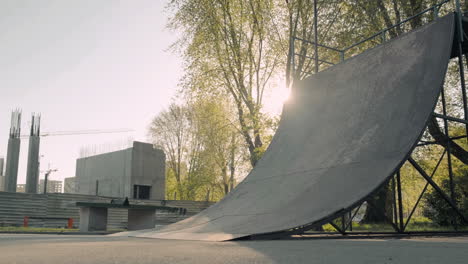 joven patinadora haciendo trucos en una rampa en un parque de patinaje al atardecer