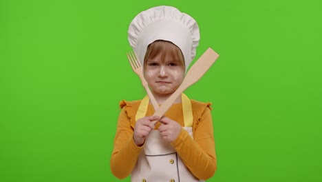 child girl kid dressed as cook chef with fork and spatula, showing symbol of rejection, disagreement