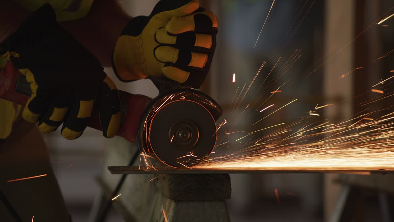 trabajador de la construcción moliendo metal y haciendo chispas, primer plano