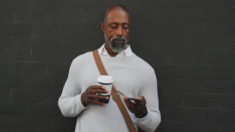 African-American-man-drinking-a-coffee-and-using-his-phone