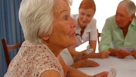 senior woman talking to senior man while sitting at dinning table