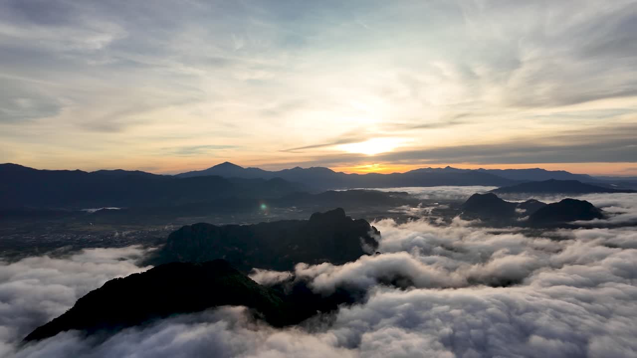 Aerial view of Vang Vieng Laos at morning sunrise above the clouds showcasing the mountain landscape and golden light