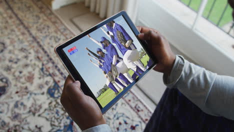 compuesto de un hombre sentado en casa, viendo un juego de béisbol durante la covid 19 en una tableta