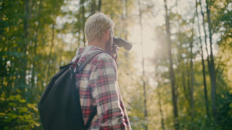 male hiker with backpack and binocular in forest