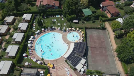 Toma-Aérea-De-La-Piscina-En-El-Camping-Europa-Silvella-Cerca-Del-Lago-De-Garda,-Italia