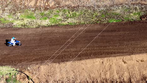 motorbike jumps over dirt track in bushland setting