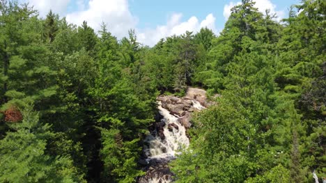 Vista-Aérea-De-Un-Arroyo-Con-Rápidos-En-Medio-De-Un-Bosque,-Duchesnay-Falls,-Ontario.