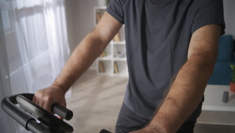 Un-Hombre-De-Mediana-Edad-Está-Entrenando-En-Bicicleta-Estática-En-Casa-Con-Un-Estilo-De-Vida-Saludable-Manteniendo-Una-Buena-Condición-Física-En-La-Mediana-Edad