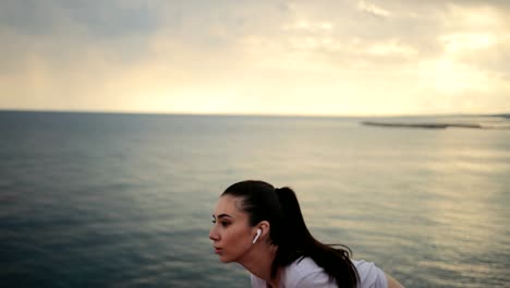 fit woman jogging and listening to music by the sea