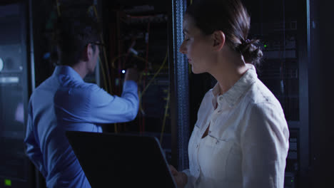 diversas mujeres y hombres técnicos de ti usando computadora portátil comprobando servidor de computadora