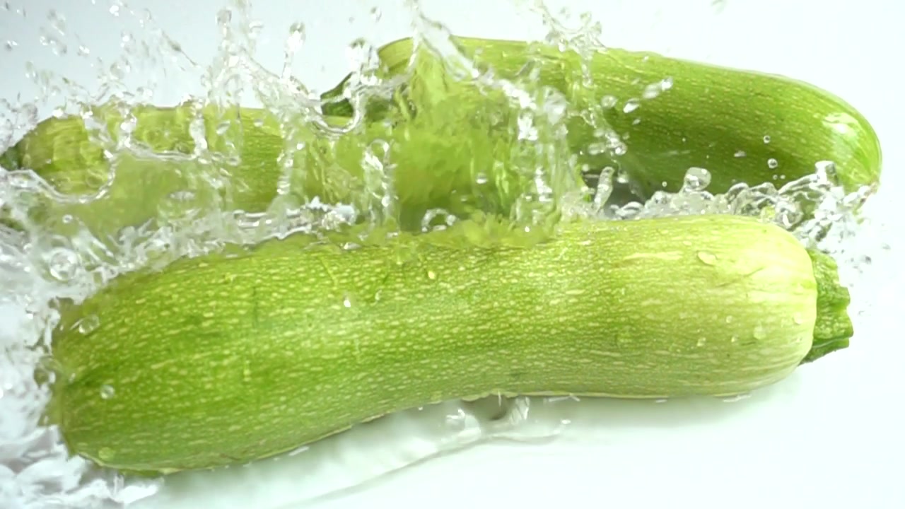 Zucchine e spruzzo d'acqua. Slow motion
