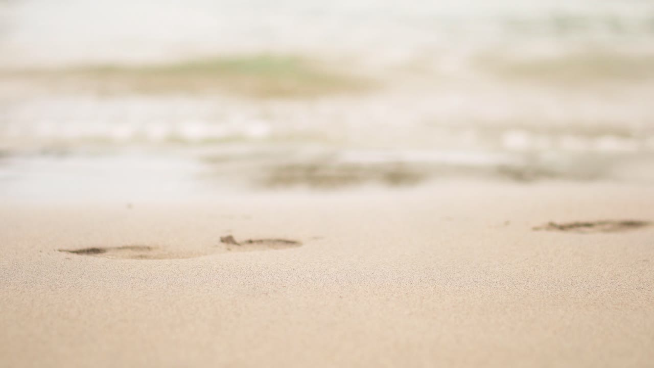 물은 모래에 여자의 발자국을 씻어