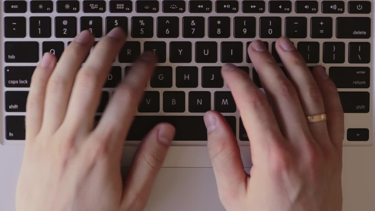 vista de arriba hacia abajo de las manos del hombre blanco escribiendo en el teclado, estático