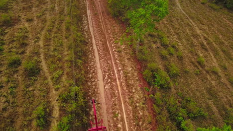 Aerial-shot-as-flying-over-people-unloading-coyol-palms-from-trailer-to-plant-them-on-the-field-for-oil-production