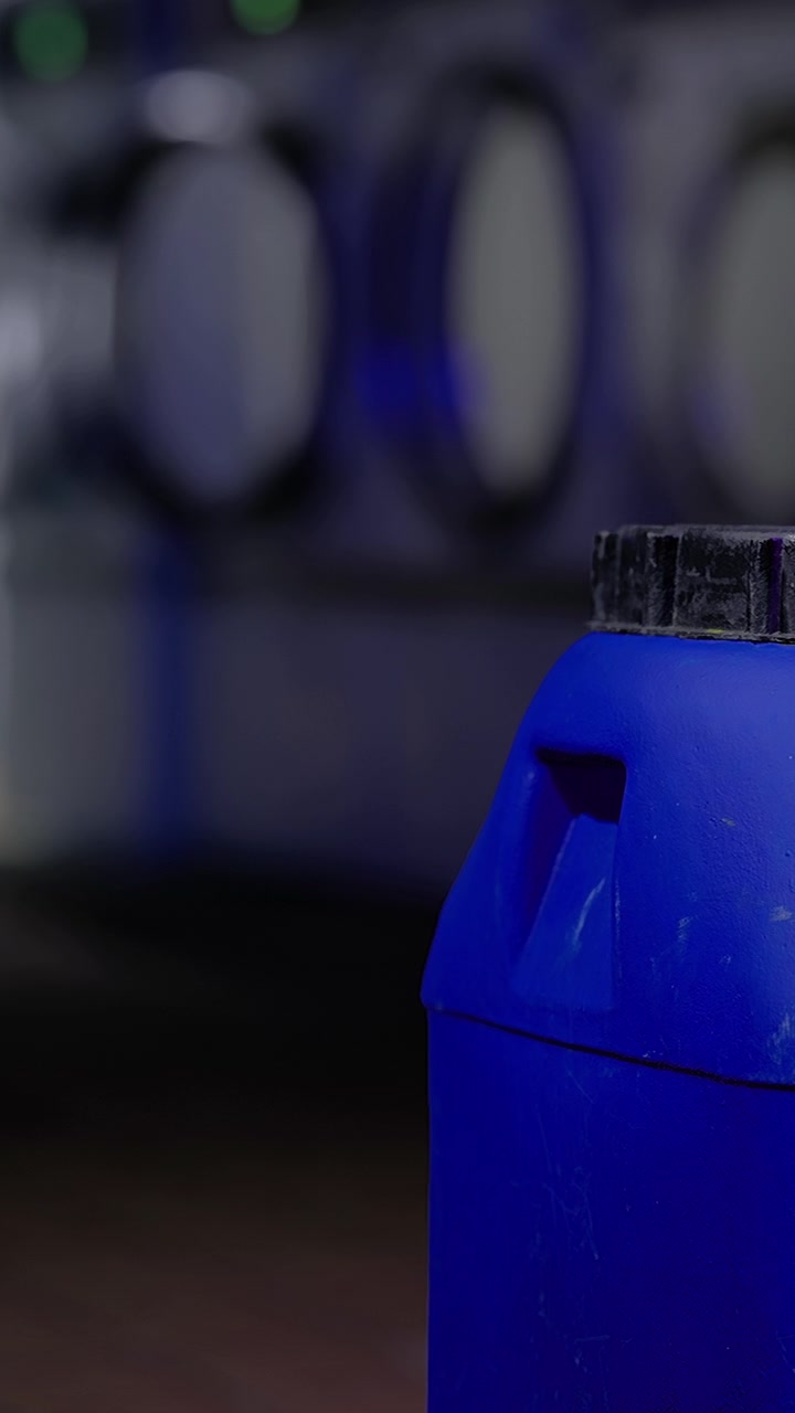 Contenedor azul brillante en un cuarto de lavado con lavadoras cerca