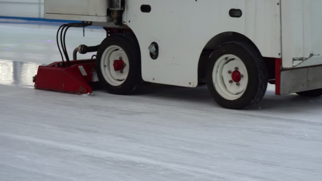 Operating Zamboni Vehicle Resurfacing Ice Skating and Hockey Rink Arena, Low Angle Tracking
