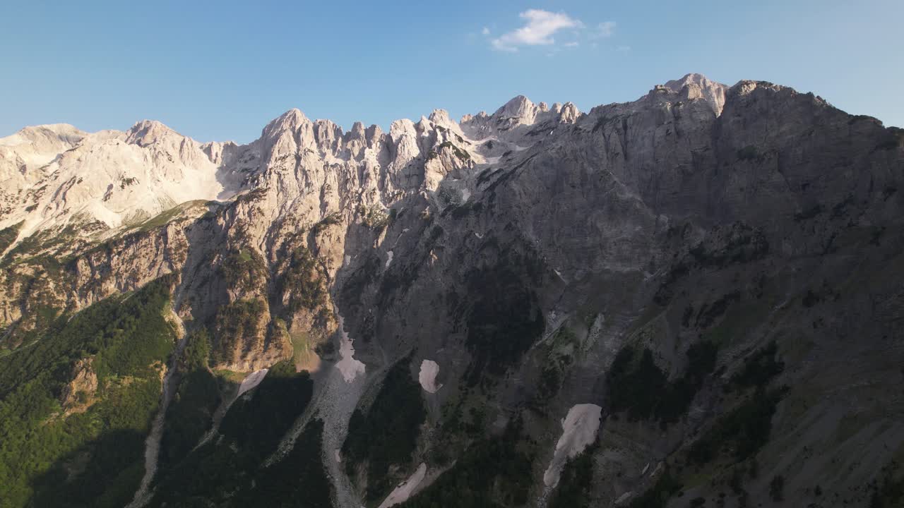 picos escarpados de las montañas alpinas con rocas cubiertas de nieve y bosques verdes en albania
