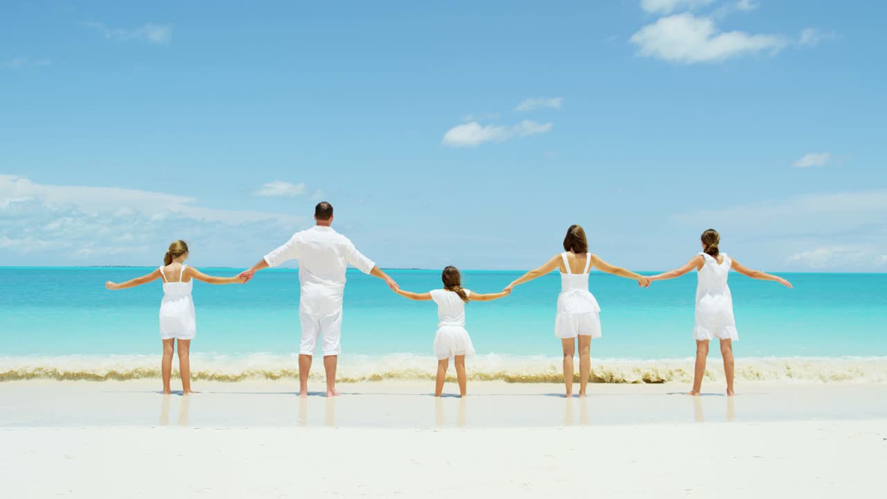 사랑하는 백인 가족이 열대 해변에서 재미를 느끼고 있습니다.