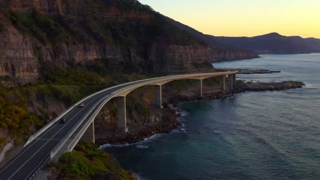 Vista-Crepuscular-Del-Hermoso-Puente-Del-Acantilado-Marino-En-Illawarra-Nsw,-Cerca-De-Sydney-Australia---Toma-Aérea-De-Drones