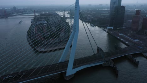 aerial approaching shot showing traffic on erasmus bridge in rotterdam during cloudy morning