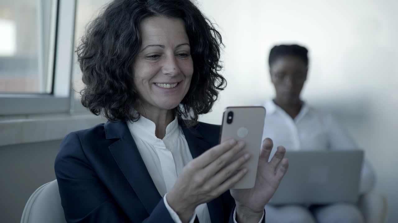 mujer de negocios alegre usando un teléfono inteligente